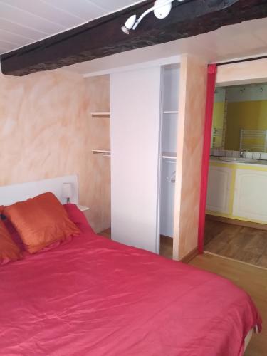 une chambre avec un lit avec une couverture rouge dans l'établissement Appartement entier idéal VTT, à Digne-Les-Bains