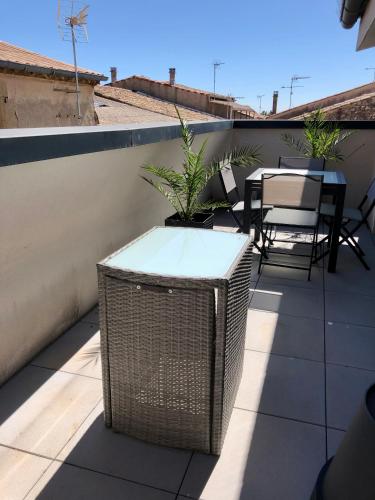 d'un balcon sur le toit avec une table et des chaises. dans l'établissement Duplex Jaden - 3 pièces climatisé 80m2, à Villeveyrac