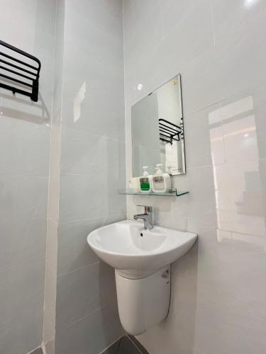 a white bathroom with a sink and a mirror at NHỚ House Đà Lạt V in Da Lat