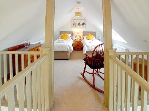 un pasillo con 2 camas y una silla en una habitación en 2 Bed in Stowmarket 80545 en Stowmarket