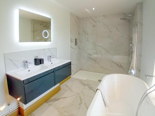 y baño blanco con lavabo y ducha. en 2 Bed in Stowmarket 80545 en Stowmarket