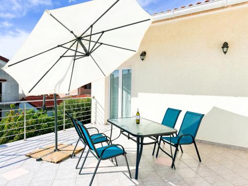 un tavolo con sedie e un ombrellone in un patio di Sunside Apartments a Pola (Pula)