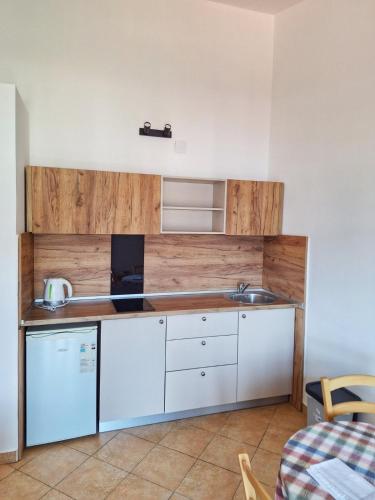 a kitchen with white cabinets and a sink at Apartmani Cupic in Budva