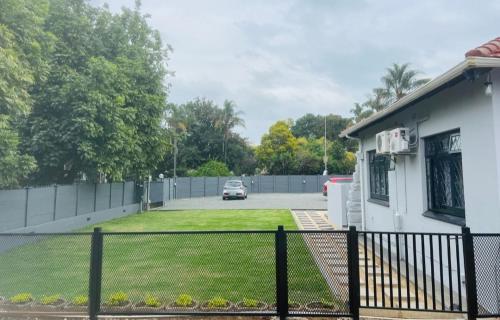 a house with a fence in front of a yard at Alberta Bed and Breakfast in Pietermaritzburg