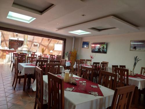 jadalnia ze stołami i krzesłami w restauracji w obiekcie Hotel San Cristobal w mieście San Cristóbal