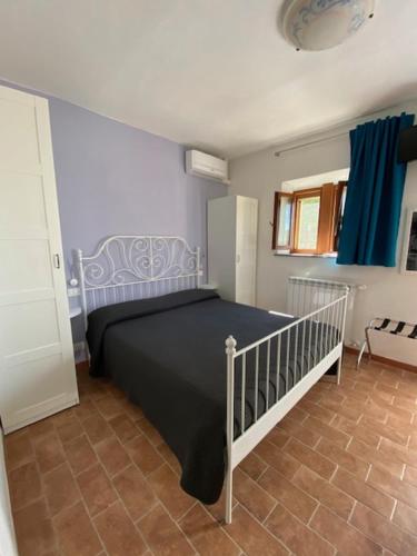 um quarto com uma cama preta e uma escada em La Fattoria di Valentina em Pomarance