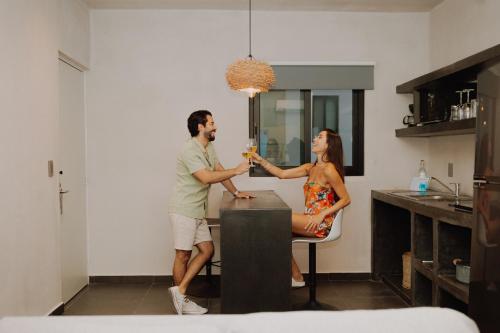 a man and woman sitting at a table with wine glasses at Coco Live Suites in Playa del Carmen
