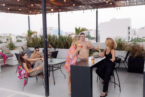 a group of people sitting around a table with drinks at Coco Live Suites in Playa del Carmen