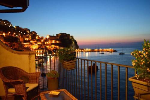 a balcony with a view of the ocean at night at B&B La Veduta in Scilla
