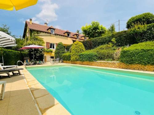 une grande piscine bleue devant une maison dans l'établissement House with swimming pool, sleeps 12, à Sarlat-la-Canéda