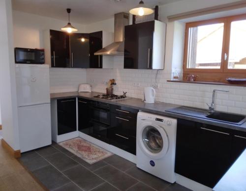 a kitchen with a washing machine and a washer at Gite de Tournieres in Tournières