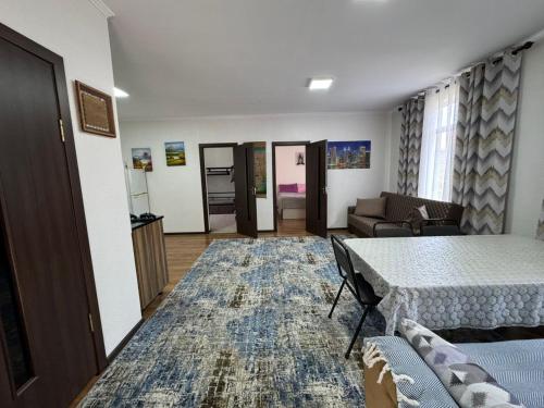 ein Wohnzimmer mit einem Tisch und einem Sofa in der Unterkunft Ай хаус in Tscholponata