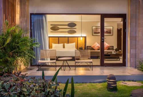 a bedroom in a villa with a table and chairs at Sanctoo Suites & Villas in Gianyar