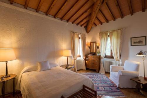 een slaapkamer met een bed en een stoel in een kamer bij Villa delle Croci in Scandicci