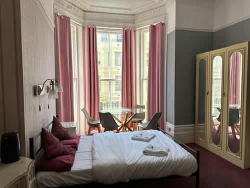 a bedroom with a large bed and a table and chairs at The Sherwood Guest House in Eastbourne