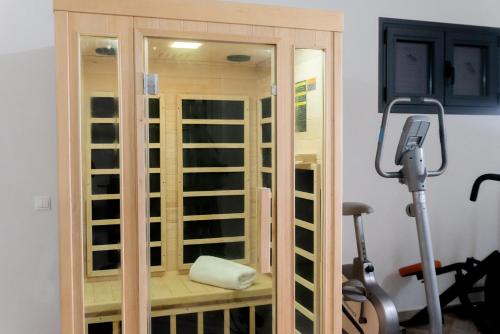 a gym with a glass door and a treadmill at Carpe Diem Moursia Studio in Liapades