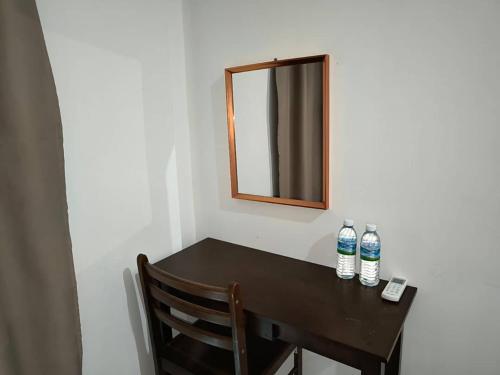 twee flessen water zittend op een tafel met een spiegel bij NaVita Lodge in Tamparuli