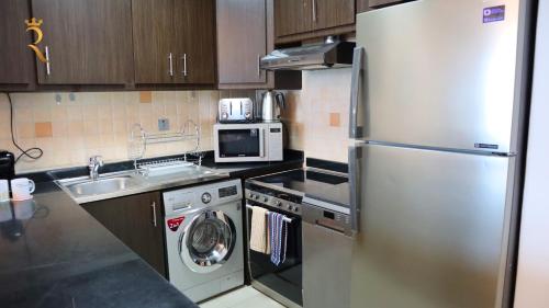 a kitchen with a stainless steel refrigerator and a dishwasher at Modern Urban Studio - Stylish Haven in Abu Dhabi