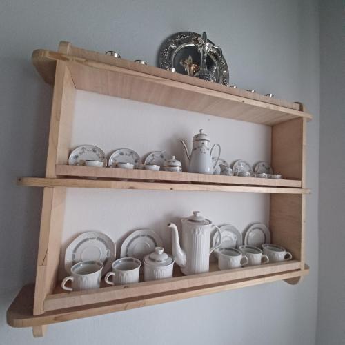 a wooden shelf with cups and dishes on it at Traditional house in the heart of Naxos in Dhamariónas