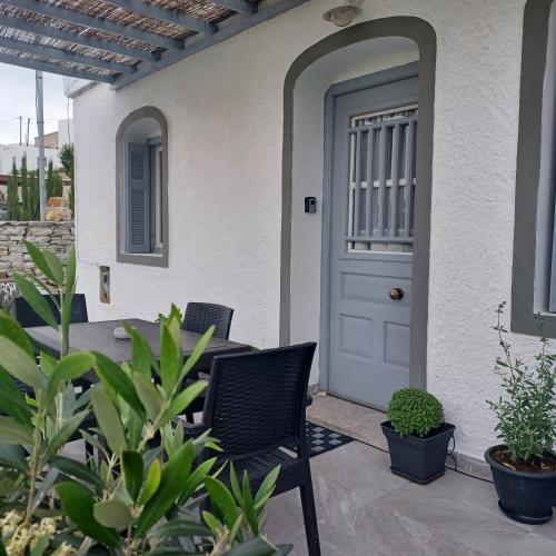 a front door of a house with chairs and plants at Traditional house in the heart of Naxos in Dhamariónas