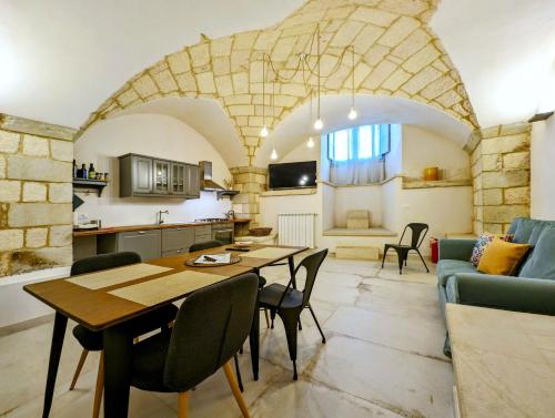 a kitchen and living room with a table and chairs at Oikia Vacanze Giuggianello Le Bey in Giuggianello