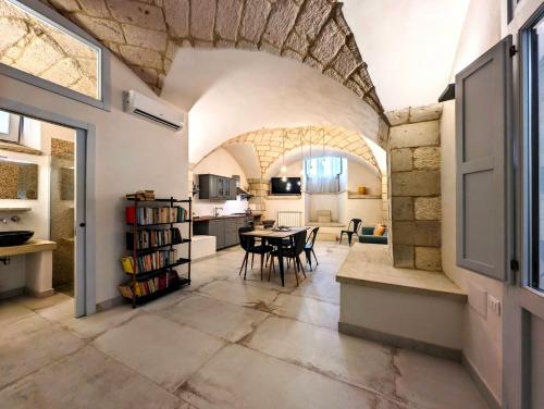 a kitchen and living room with a table and chairs at Oikia Vacanze Giuggianello Le Bey in Giuggianello