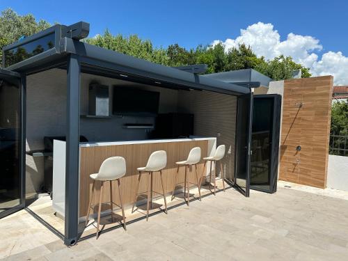 a group of chairs sitting around a bar on a patio at Villa Azure Krimovica Kotor in Krimovice