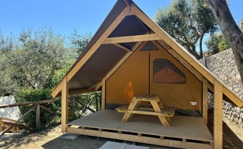 索倫托的住宿－Hostel Santa Fortunata，一个带木门廊的小黄色帐篷