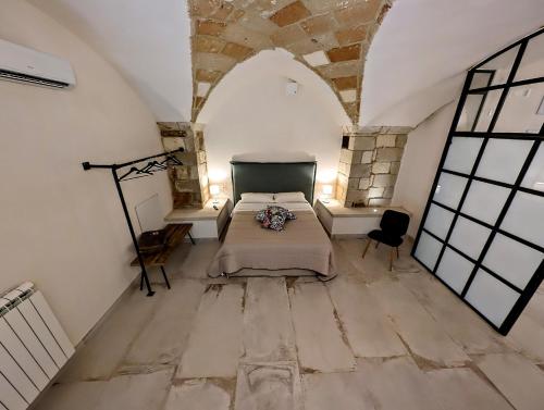 a bedroom with a bed and two tables in a room at Oikia Vacanze Giuggianello Le Bey in Giuggianello