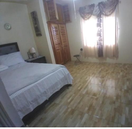 a bedroom with a bed and a wooden floor at Cheerful VinAdas in Mandeville