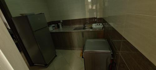 a small kitchen with a sink and a refrigerator at Les portes de Gueliz - apartment 6 people in Marrakech