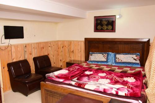 1 dormitorio con 1 cama y 1 silla en Quality Inn Hotel en Murree
