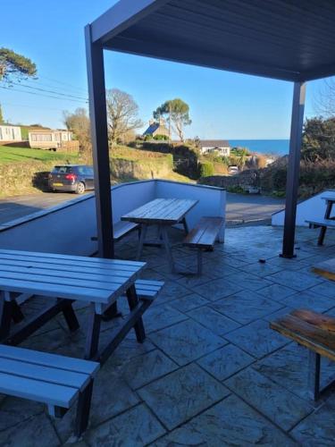 a group of picnic tables sitting under a pavilion at Caravan at Harbour House in Moelfre