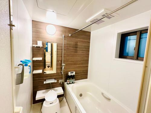 a bathroom with a tub and a toilet and a sink at MoRi House IN西日暮里Ⅱ in Tokyo
