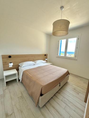 um quarto com uma cama grande e uma janela grande em Bilocale Bellavista em Marettimo