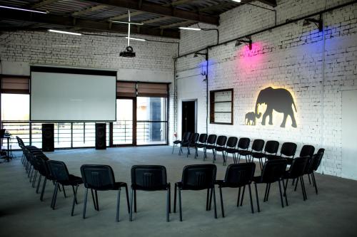 a conference room with chairs and a projection screen at Ostrov River Club in Novosëlovka