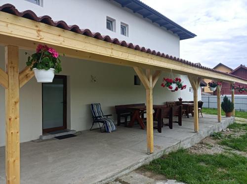 a patio with a wooden pergola and a table at Pensiunea Ileana in Novaci