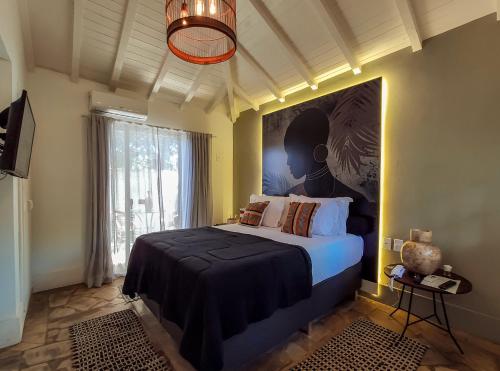 1 dormitorio con 1 cama y una gran pintura en la pared en Taman Búzios Hotel, en Búzios