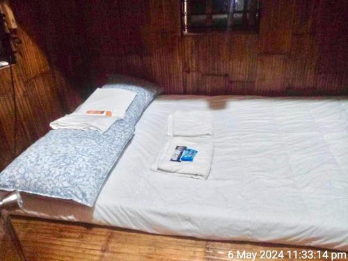 Una cama con sábanas blancas y toallas. en Catalinas Mini-Farm en Victoria