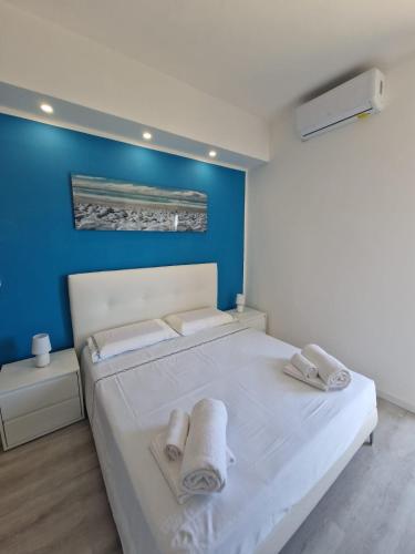 ein Schlafzimmer mit einem weißen Bett und Handtüchern darauf in der Unterkunft Residenza Luigiò in Verbania
