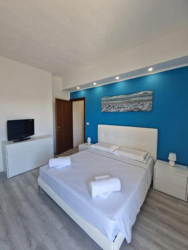 ein Schlafzimmer mit einem großen weißen Bett und einer blauen Wand in der Unterkunft Residenza Luigiò in Verbania