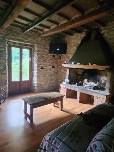 a living room with a fireplace and a wooden table at Contea del Piano in Piteglio