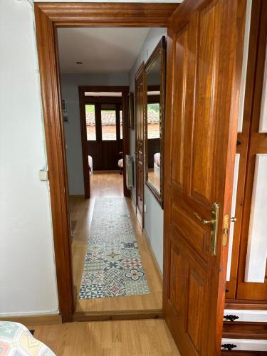 a hallway with a wooden door and a rug at Casa rural in Mestas del Con