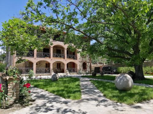 a large house with a tree and a driveway at Château Fort de Manavi, Boutique Hotel in Manavi