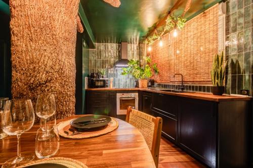 a kitchen with a wooden table with wine glasses at Jungle Love Room in Toulouse