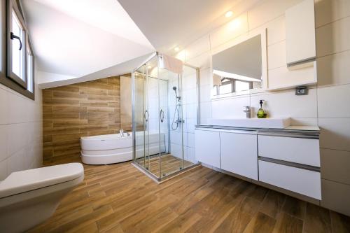 La salle de bains est pourvue d'une douche en verre et de toilettes. dans l'établissement Turquoise Shores Family-Friendly Luxury Villa Fethiye Oludeniz by Sunworld Villas, à Fethiye