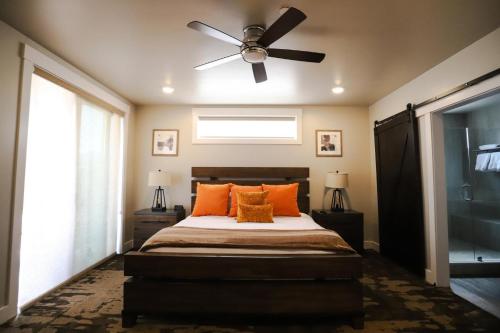 1 dormitorio con ventilador de techo y 1 cama con almohadas de color naranja en Sage Creek E3 in Moab with Private Hot Tub and Community Pool en Moab