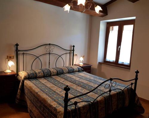 1 dormitorio con 1 cama, 2 lámparas y 2 ventanas en Agriturismo Casale Tozzetti, en Norcia