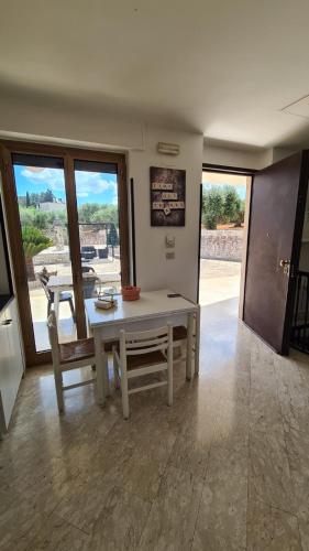 a dining room with a table and some windows at Happy's Casa in Putignano