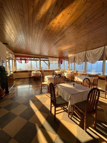 jadalnia ze stołem, krzesłami i oknami w obiekcie Villa Selene w Tremosine Sul Garda